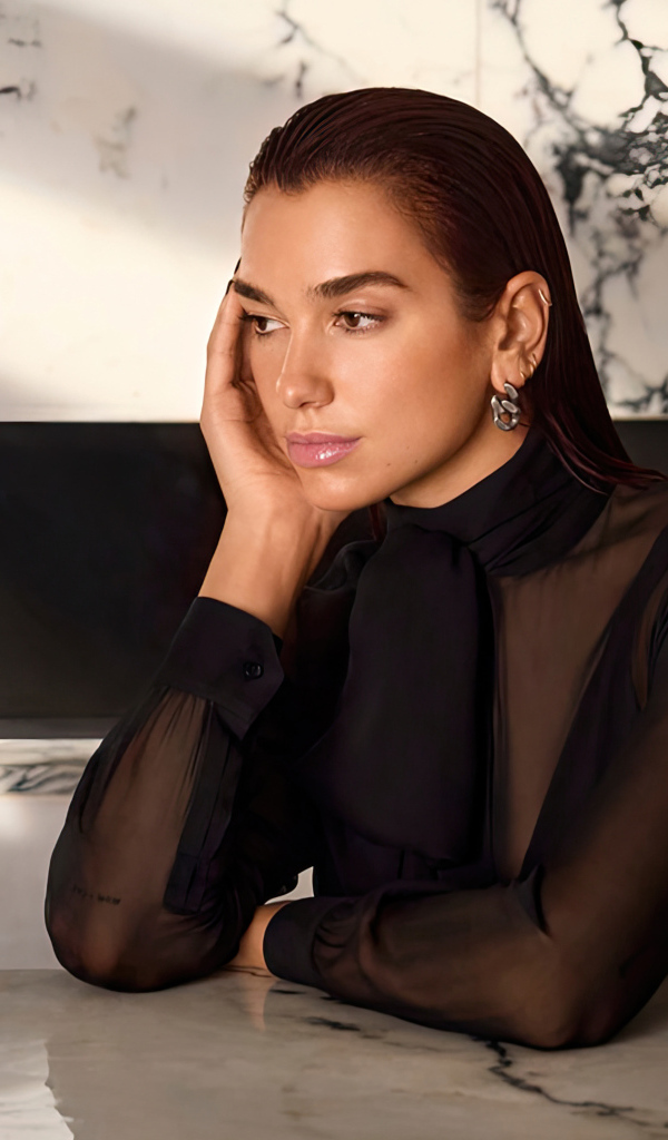 Грустная певица Дуа Липа сидит за столом