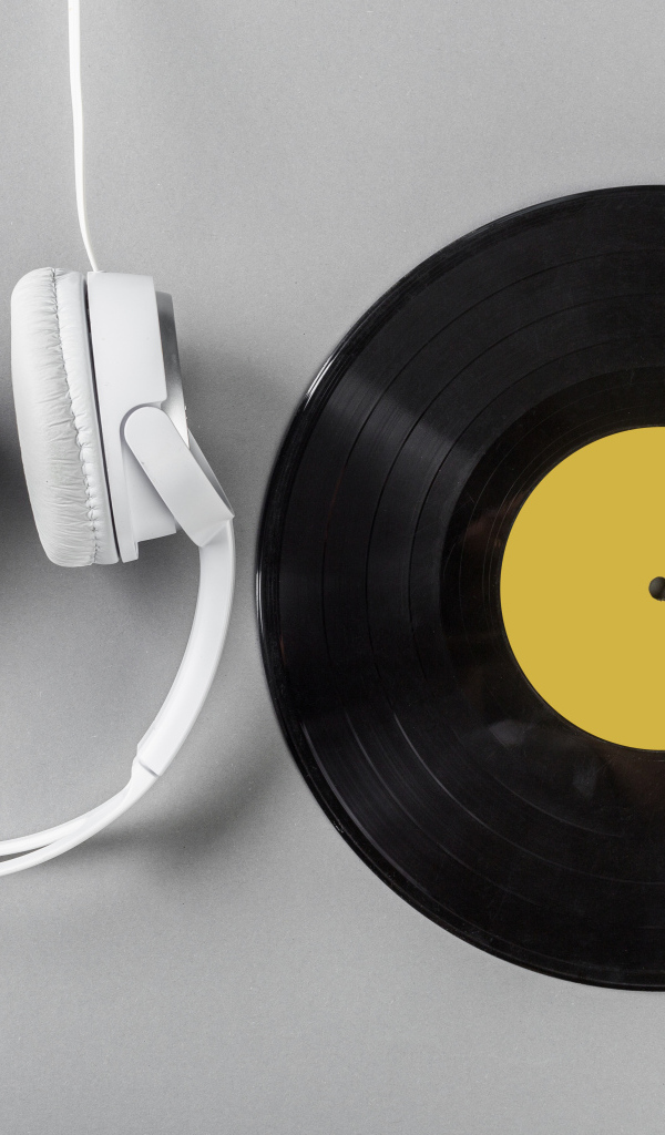 Виниловая пластинка и наушники на сером столе