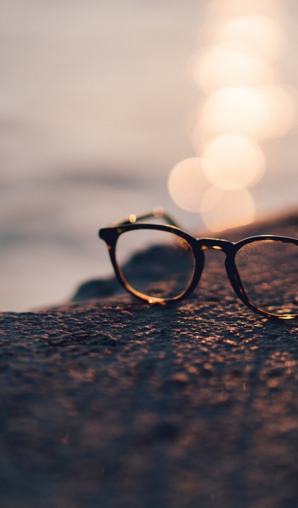 Очки лежат на камне в лучах солнца