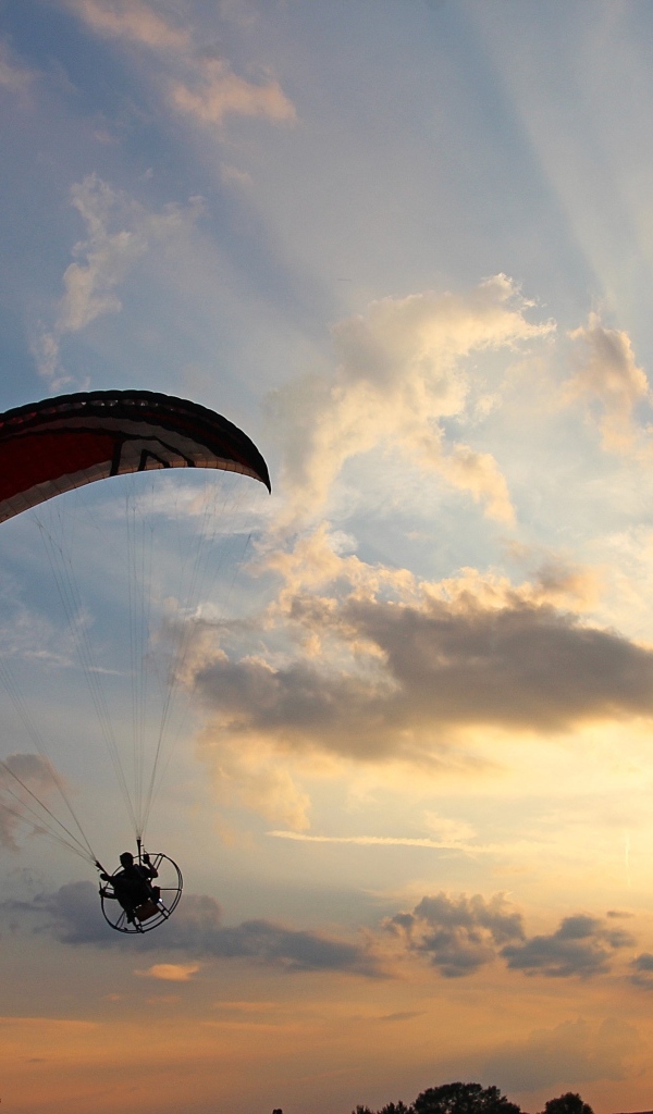 Параплан в небе на фоне солнца