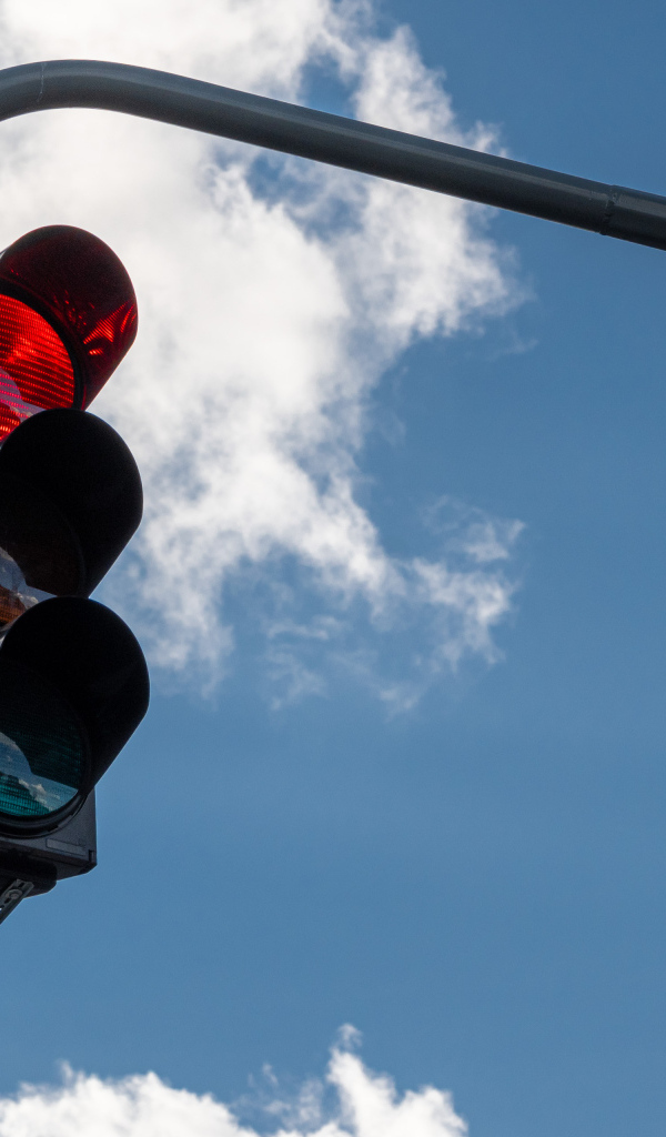 Красный свет светофора на фоне неба