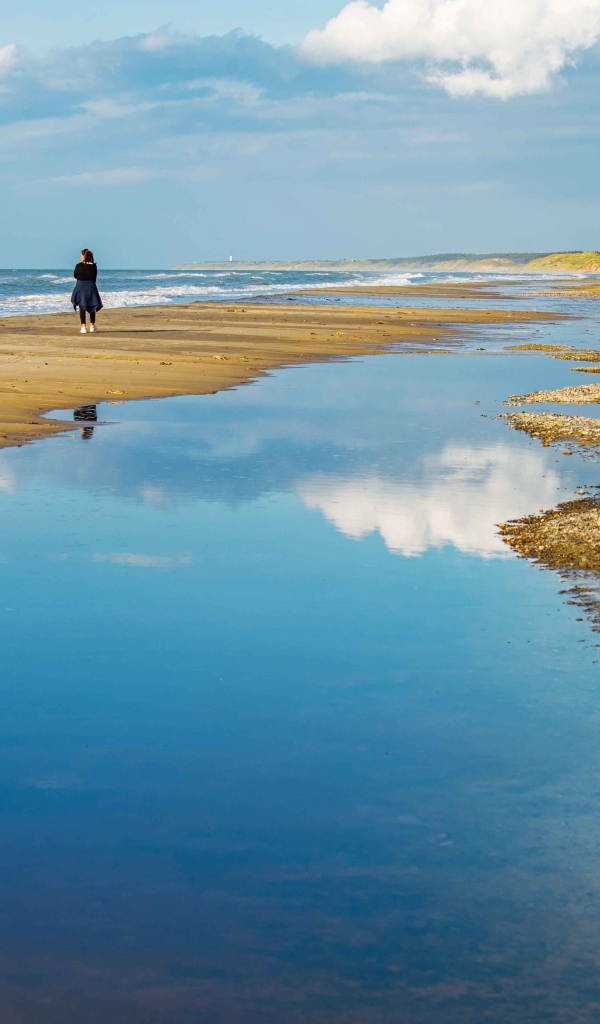 Небо отражается в воде на берегу моря