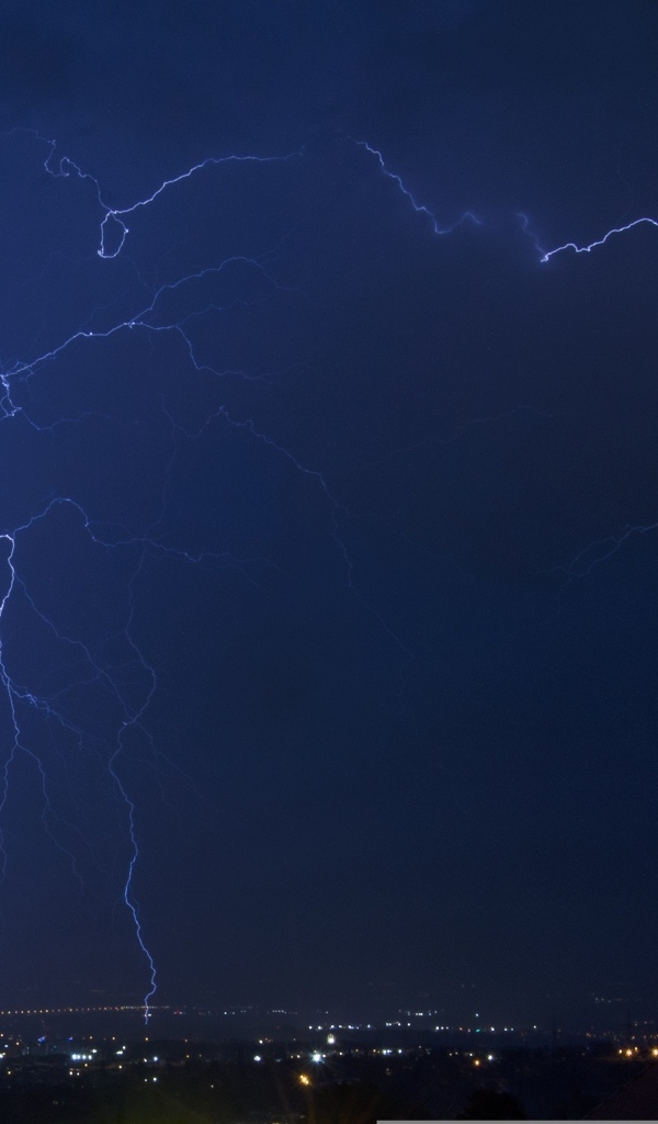 Белая яркая молния в небе над городом