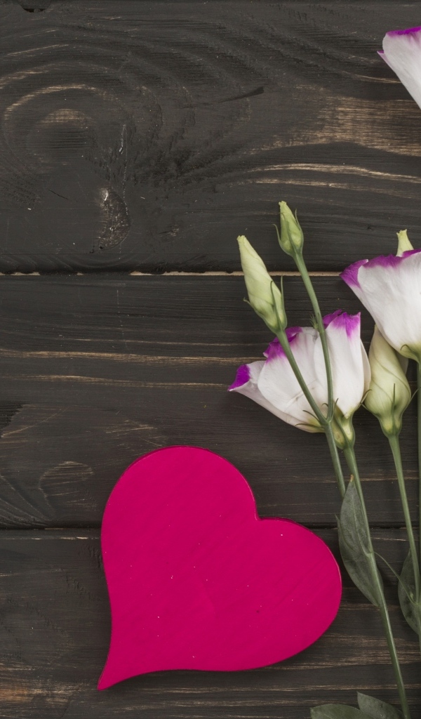 Нежные цветы эустомы с красным сердцем на деревянном фоне