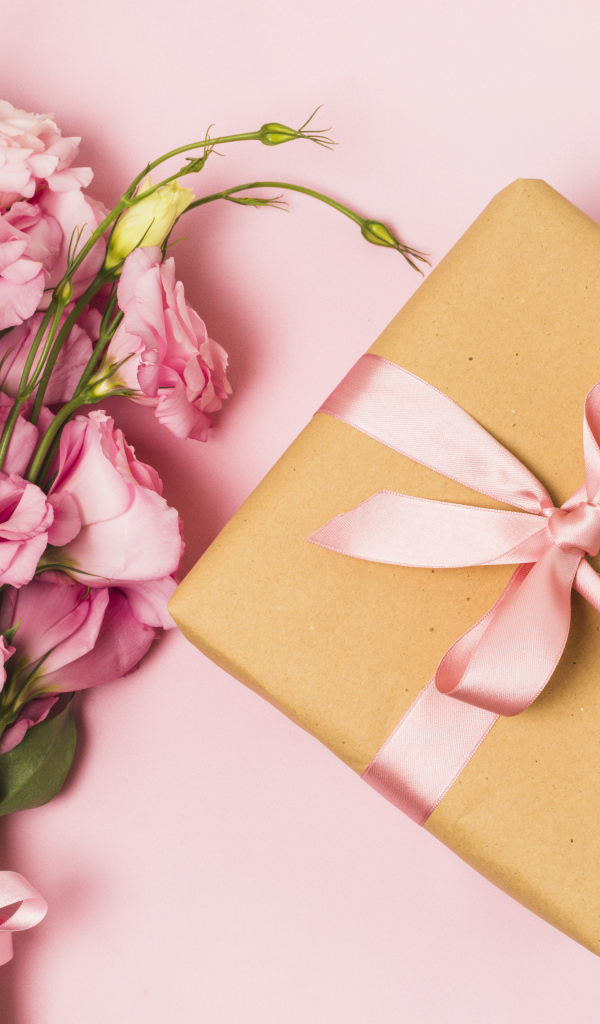 Большой букет эустомы с подарком на розовом фоне