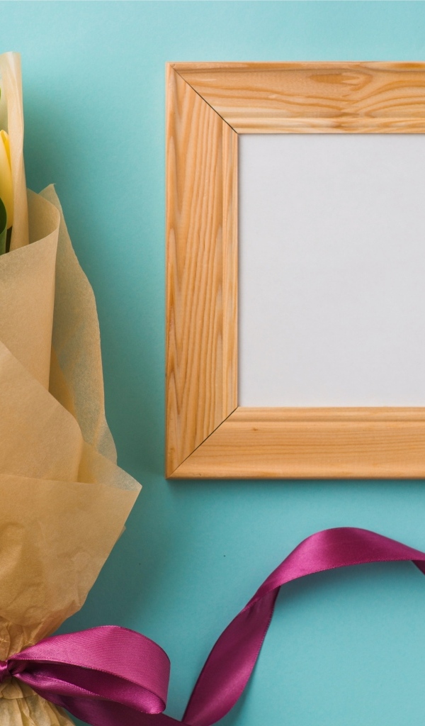 Деревянная рамка с букетом желтых тюльпанов на голубом фоне