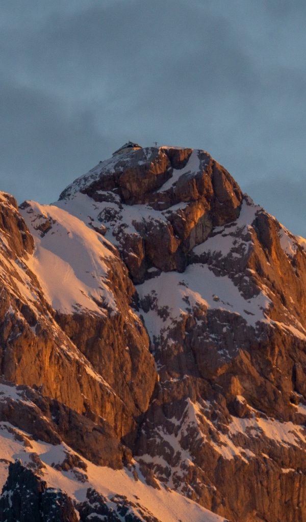 Высокие опасные заснеженные горы под грозовым небом