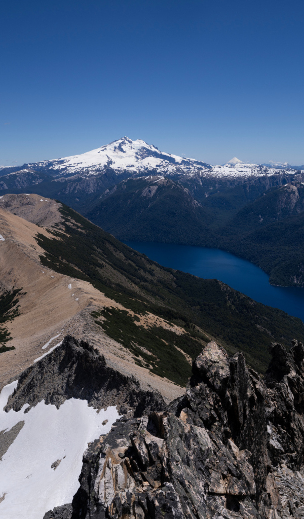 Высокие заснеженные горы и река под голубым небом