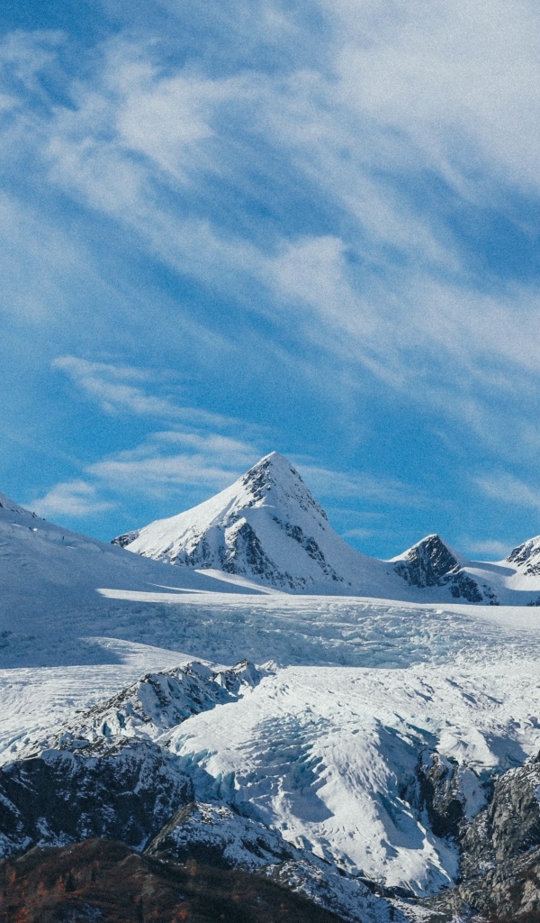 Высокие заснеженные горы под голубым ясным небом