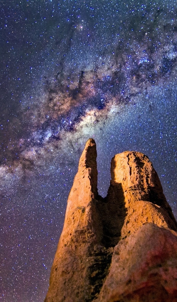 Млечный путь в звездном небе над острой  горной вершиной