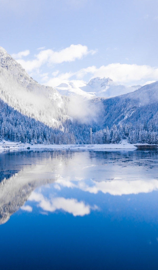 Покрытые снегом горы у покрытого льдом озера