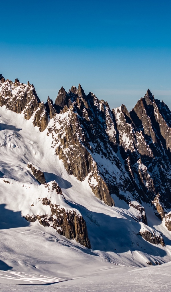 Солнце покрывает заснеженные горы