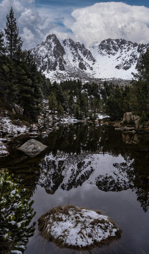 Холодная вода в озере с большими камнями на фоне гор