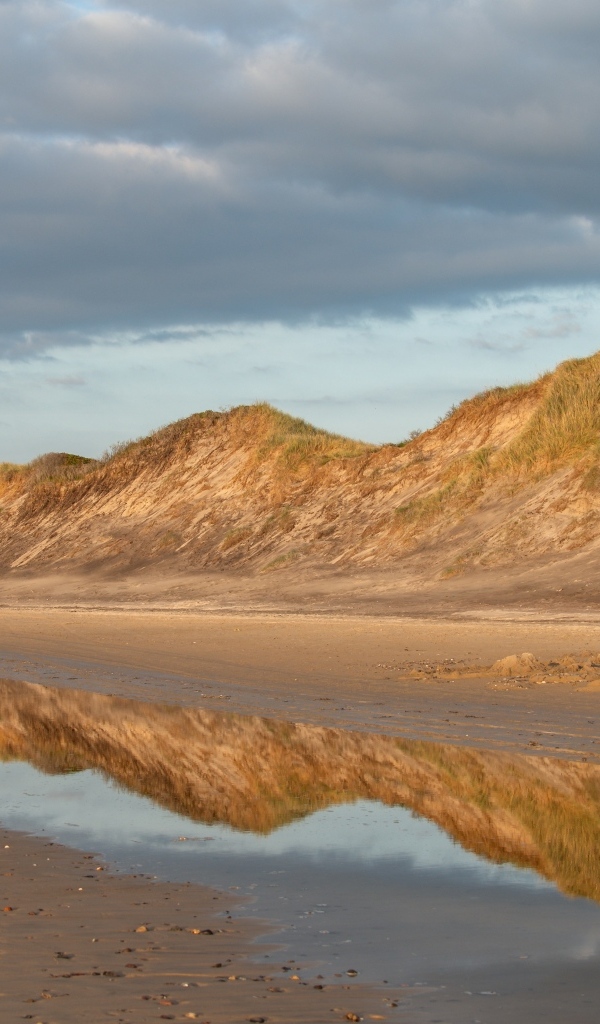Холты отражаются в реке под грозовым небом