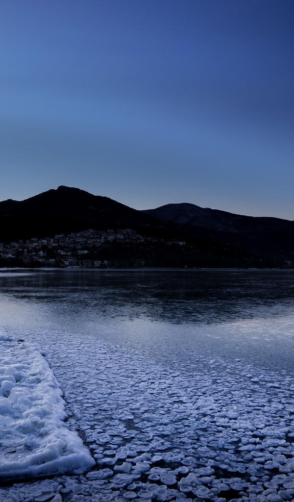 Заледеневшая вода в горном озере в сумерках