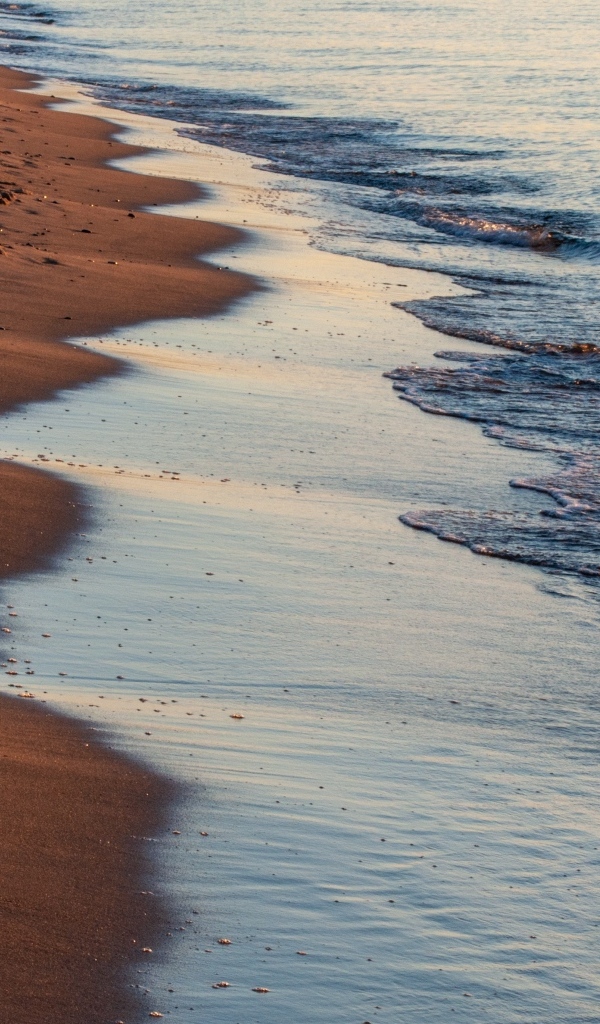 Спокойное море на морском песке на рассвете