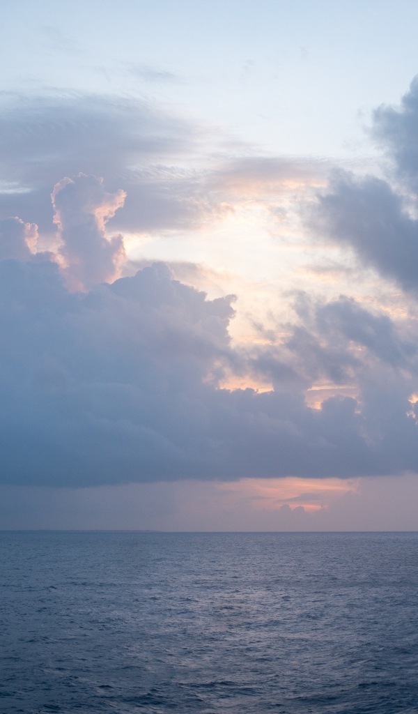 Густые белые облака над морем на рассвете летом