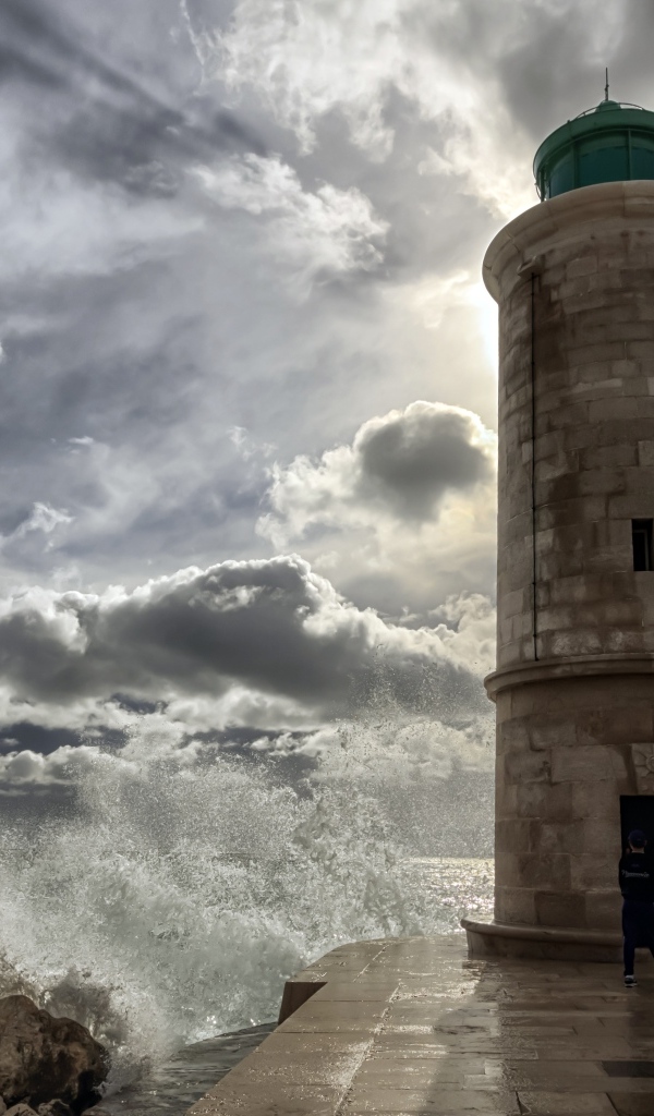 Волны бьются о маяк под красивым небом