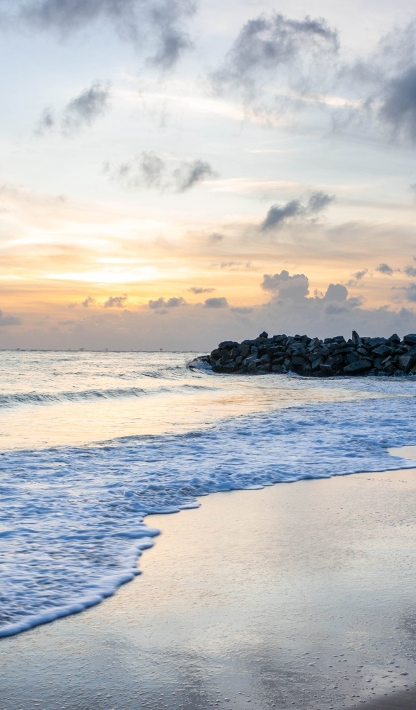 Волны омывают морской песок на рассвете