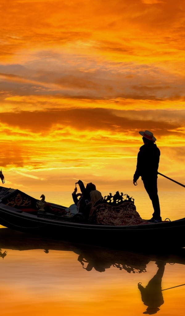 Мужчина на гондоле на закате