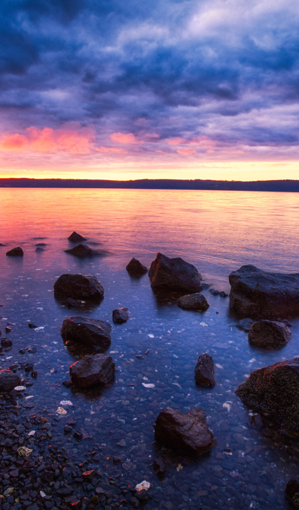 Закат солнца в пасмурном небе у озера