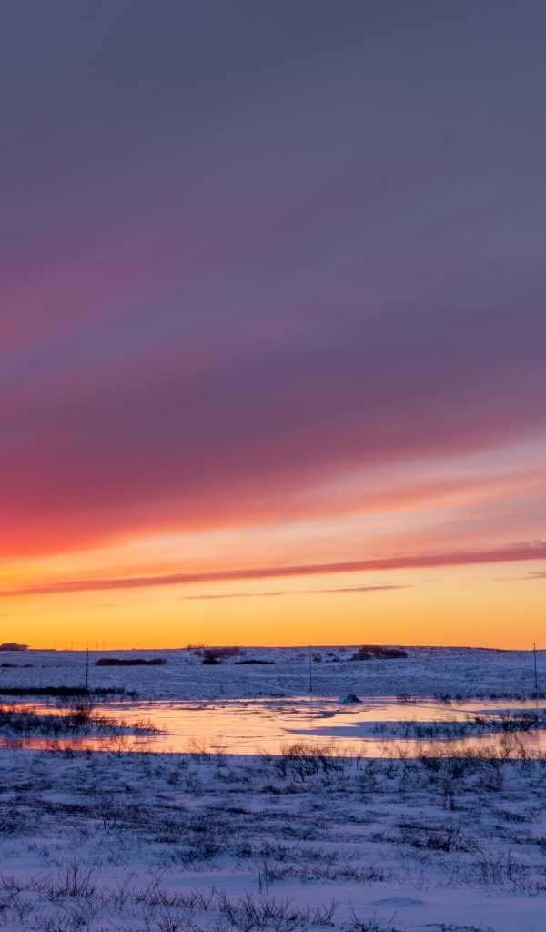 Закат солнца над покрытым снегом полем Аляски