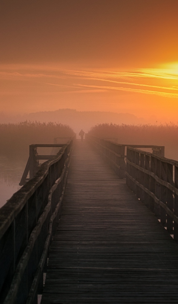 Деревянный мост над рекой на закате