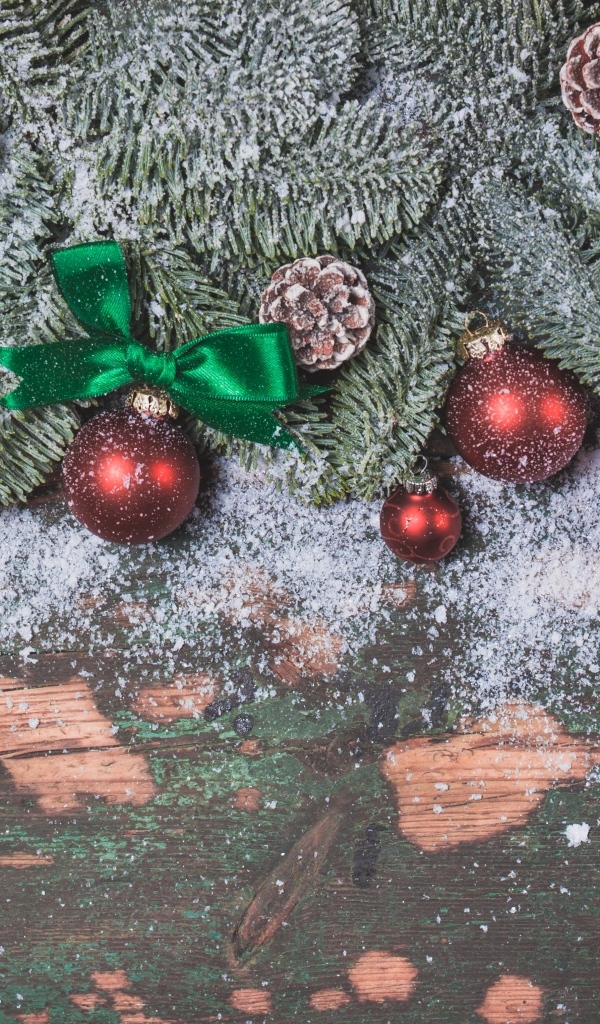 Зеленые заснеженные еловые ветки с красными шариками
