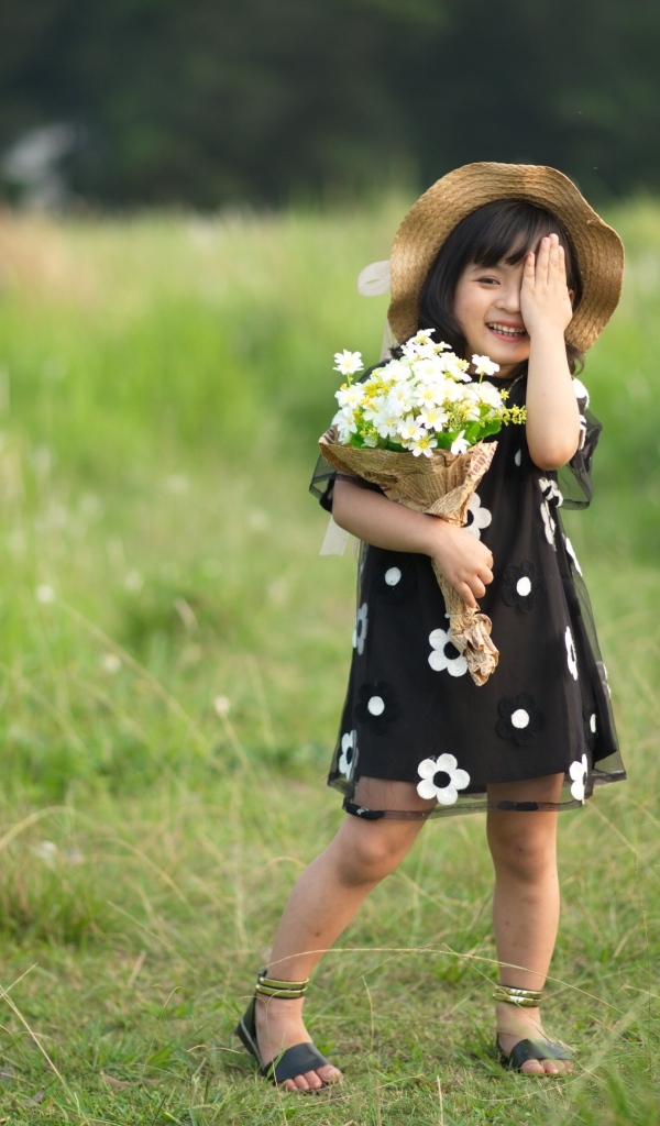 Девочка азиатка в шляпе с букетом цветов