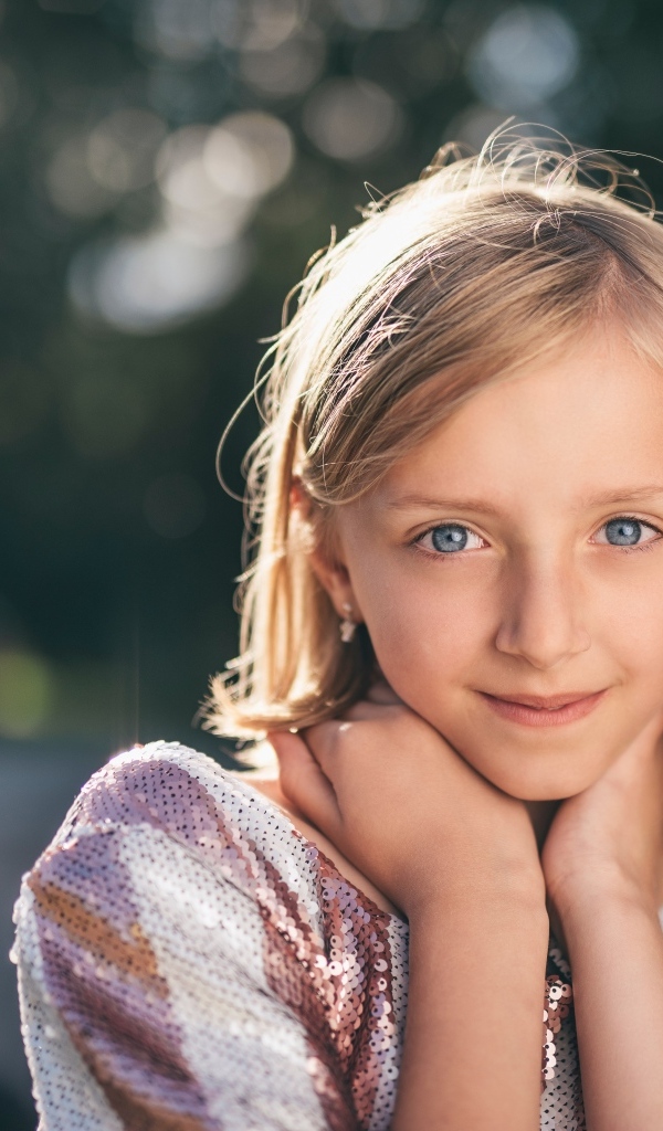 Красивая голубоглазая девочка в лучах солнца