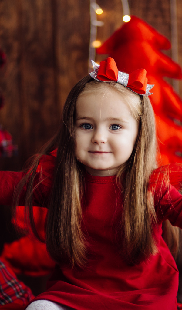 Красивая маленькая длинноволосая девочка в красном платье