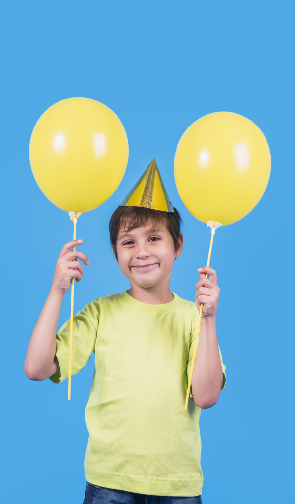 Мальчик на день рождения с желтыми шариками