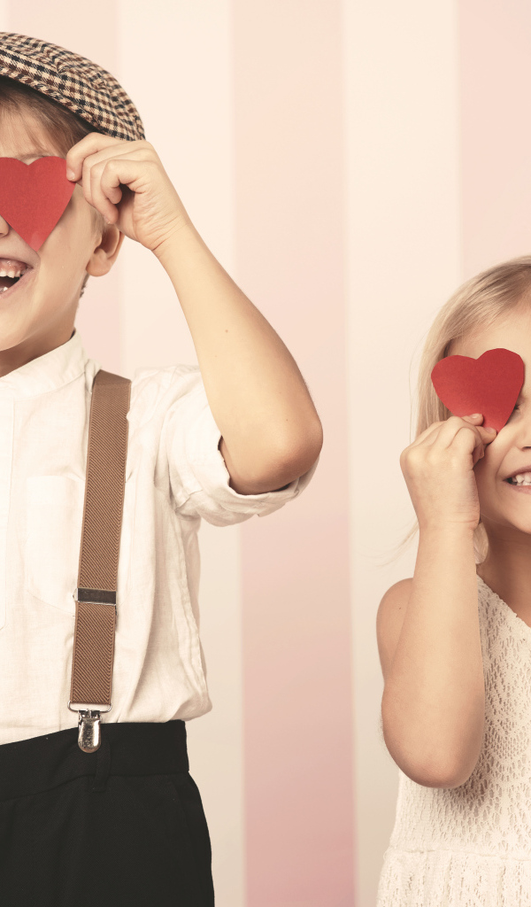 Мальчик и девочка с сердечками в руках
