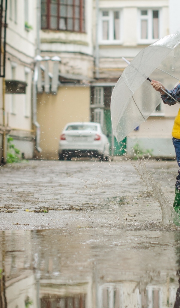 Мальчик с зонтом прыгает по лужам