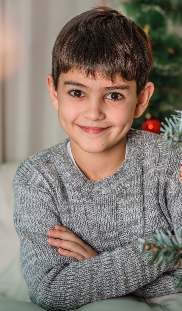 Кареглазый мальчик у новогодней ели