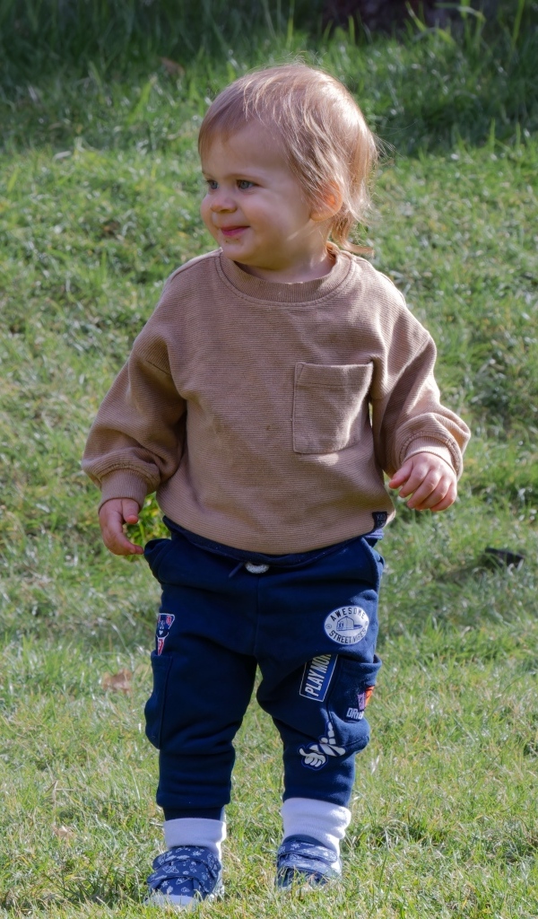 Веселый маленький мальчик гуляет на природе