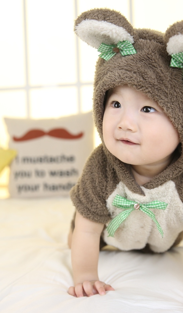 Ребенок в костюме медвежонка на кровати