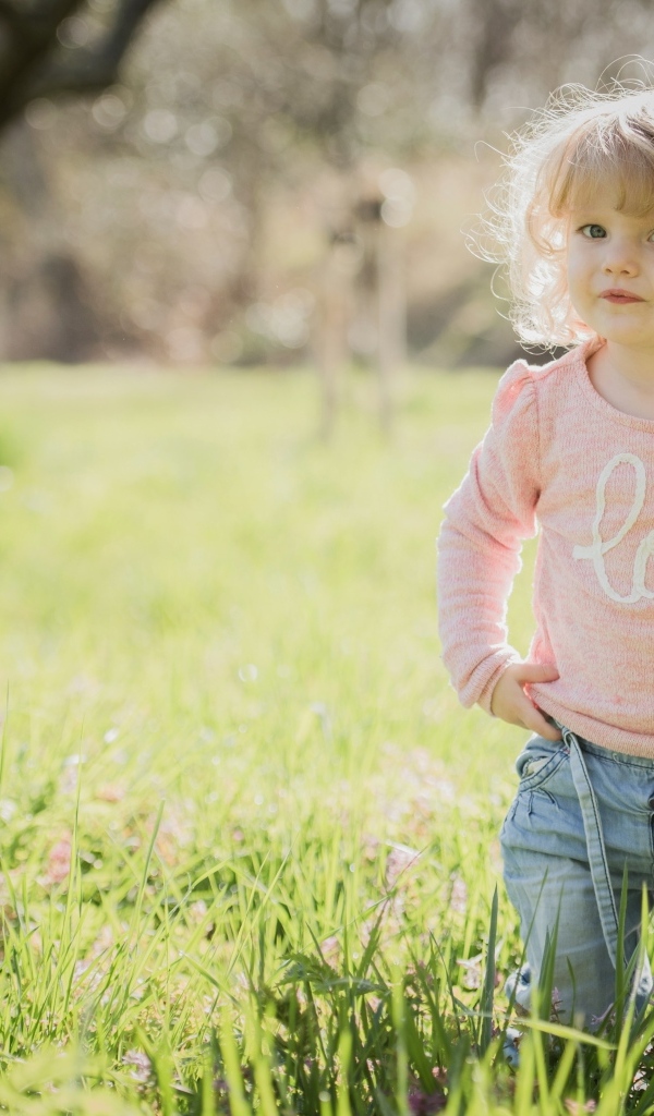 Кудрявая девочка в зеленой траве