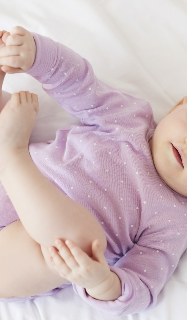 Милый голубоглазый малыш на белом покрывале