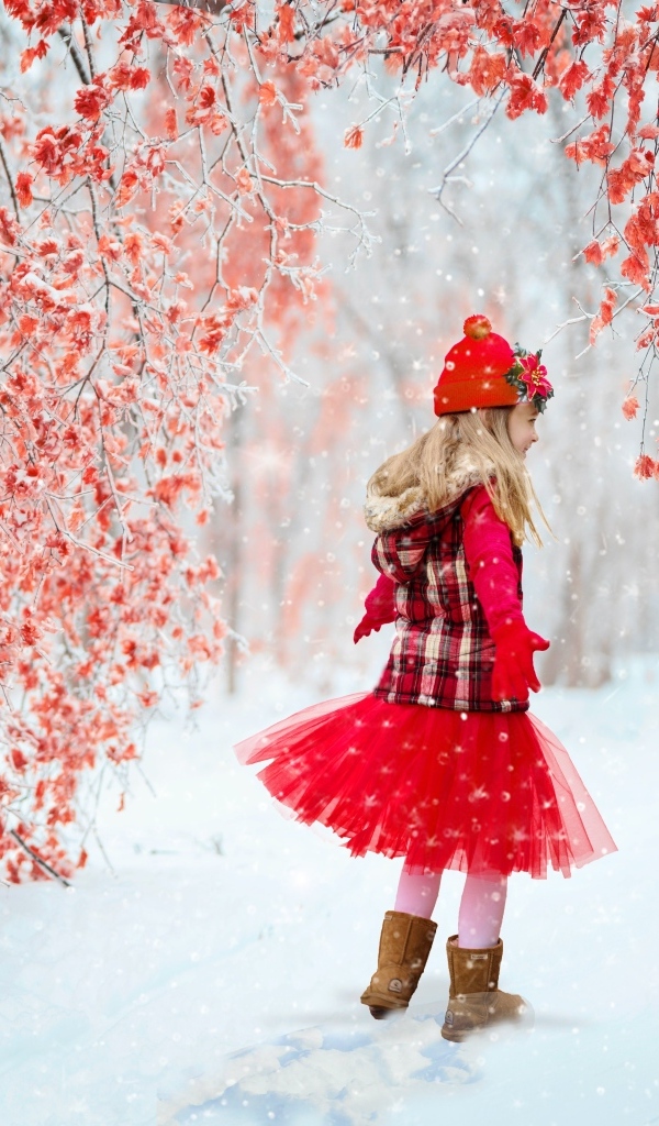 Милая девочка в заснеженном лесу с деревьями с красными листьями