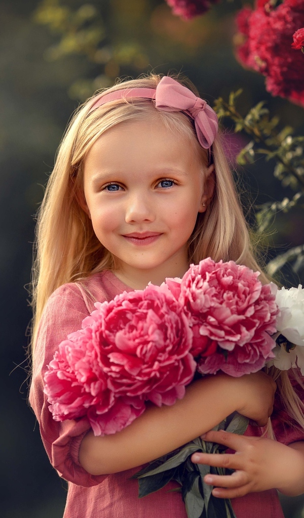 Милая маленькая девочка с букетом пионов