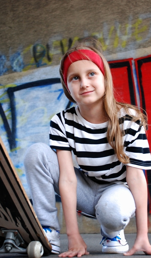 Милая маленькая девочка со скейтбордом