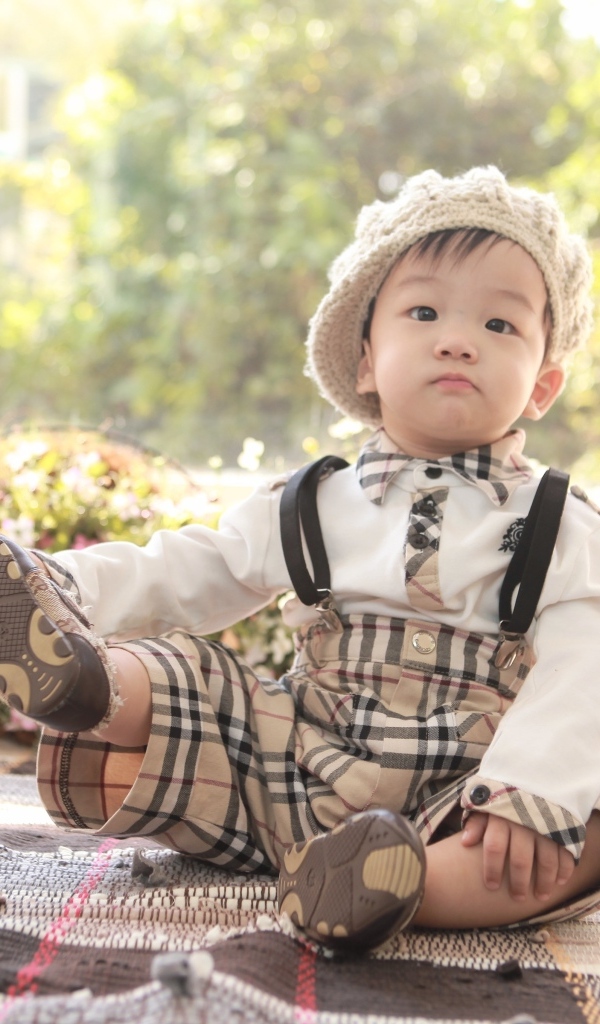 Смешной мальчик азиат у цветов