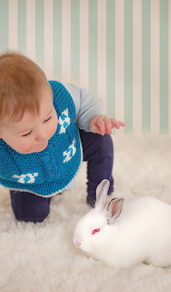 Смешной маленький мальчик с белым кроликом