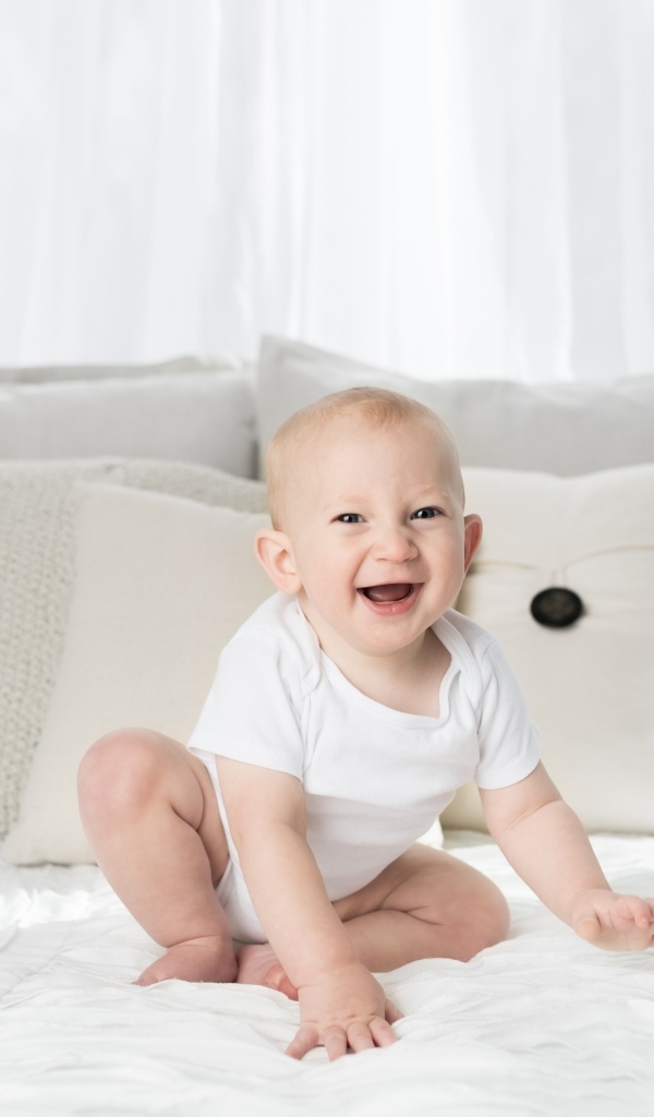 Смешной маленький ребенок на кровати