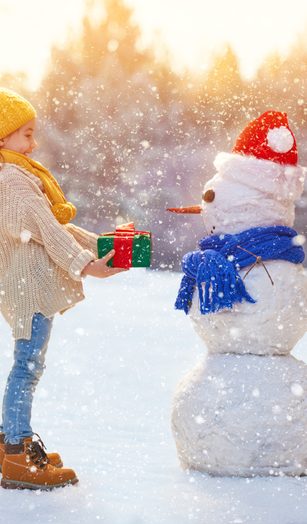 Девочка дарит подарок снеговику