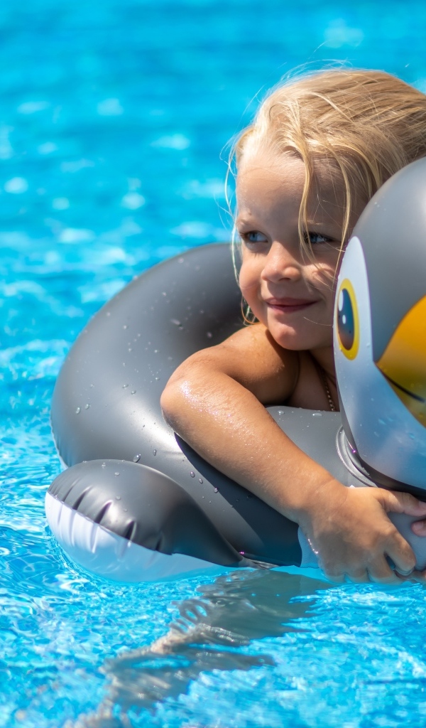 Девочка со спасательным кругом в бассейне
