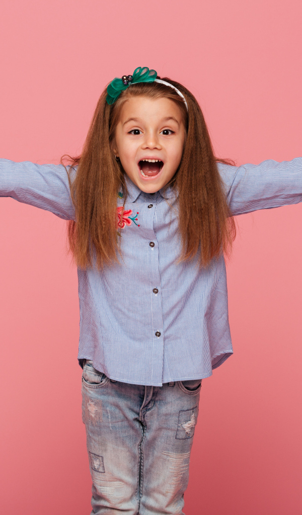 Счастливая маленькая девочка на розовом фоне