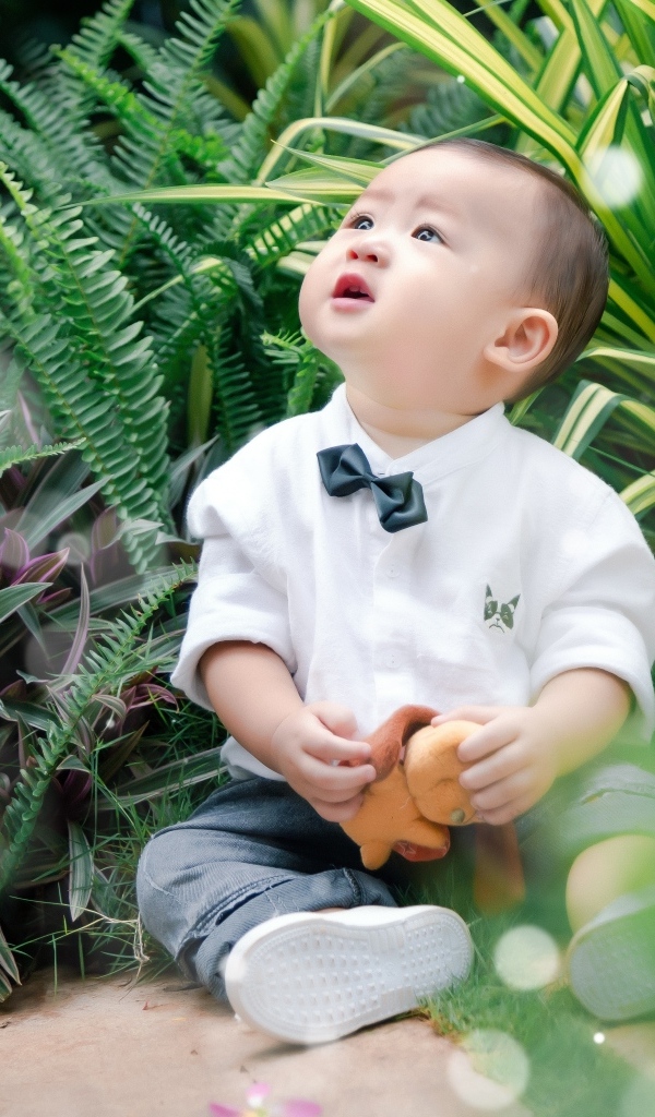 Маленький азиатский ребенок в зеленой траве