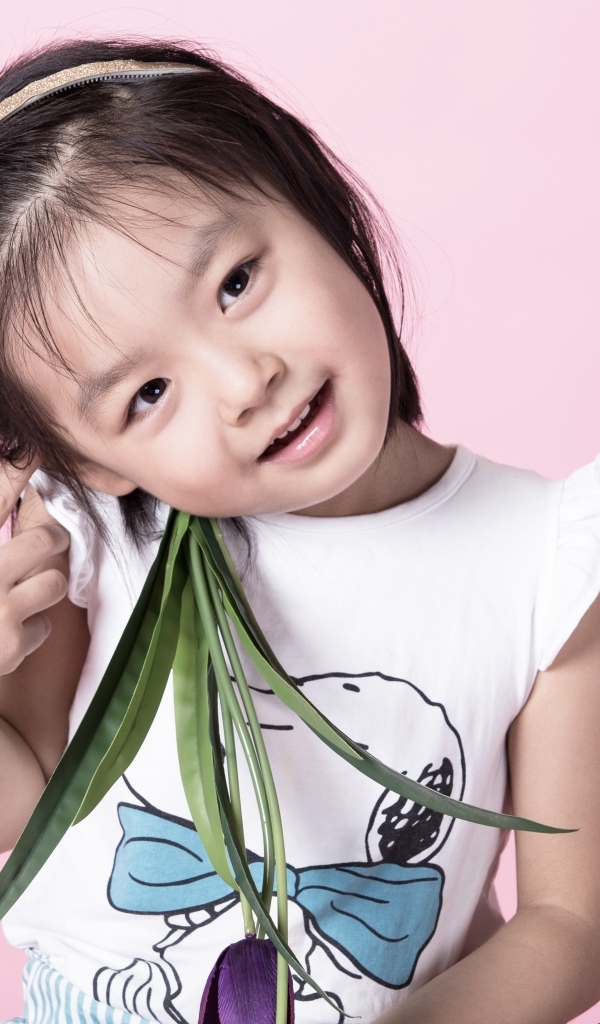 Маленькая девочка азиатка на розовом фоне